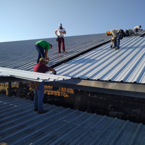 men installing white metal roofing